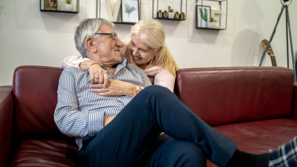 istock Woman embracing husband sitting on the couch 1403816133