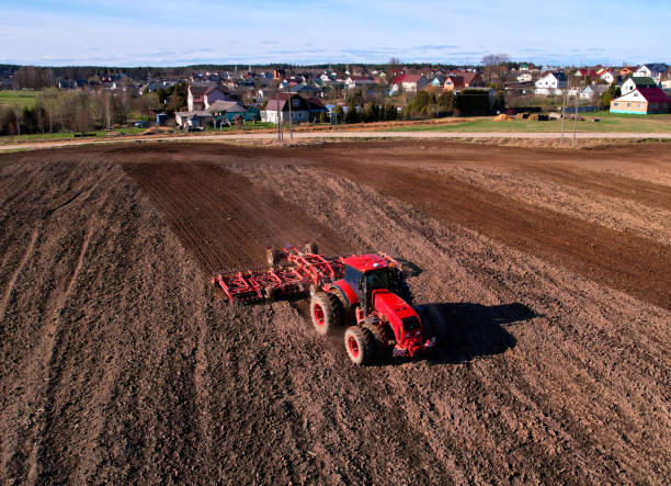 istock Tractor plowing field. Tractor plow soil cultivating. 1403816278