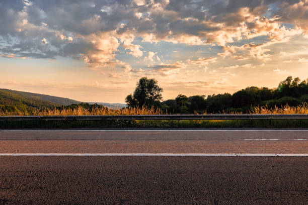 Empty road in green nature from low angle with blue dramatic sky and clouds in the background. Idea for composite or sky replacement.Copy space provided.