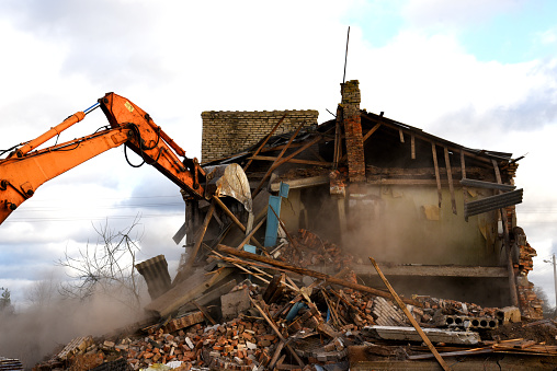 Contrast of demolished old house and modern skyscraper.