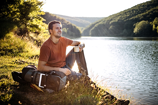Male mountaineer enjoys himself by the lake
