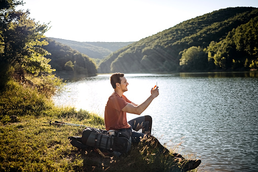 Male mountaineer enjoys himself by the lake