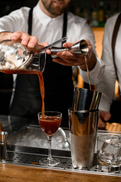 istock close-up on shaker cups and a wineglass into which hands of different bartenders pour drinks 1403822121