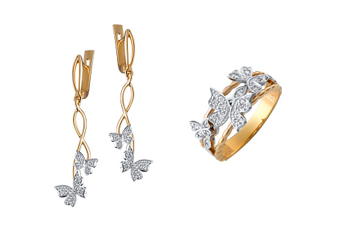 A closeup shot of the gold earrings and ring with diamond butterflies isolated on the white background