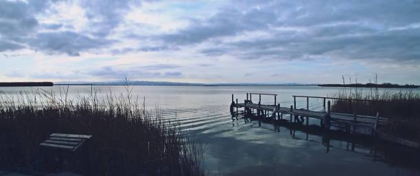 Wooden jetty in a lagoon at sunset.