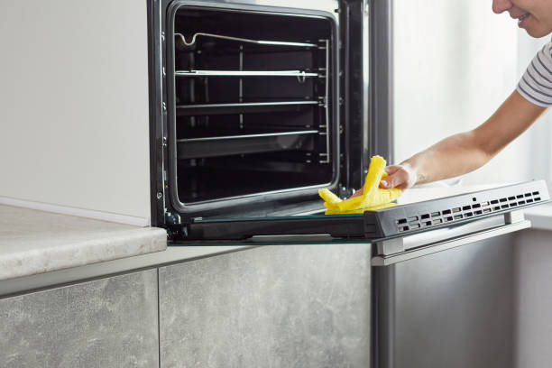 istock Easy Cleaning the oven concept. Female hand cleaning kitchen oven. 1403828342