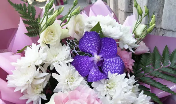 Large bouquet with asters and orchid. Purple orchid in a bouquet. Bouquet of white-lilac with pink paper. Beliy astri.