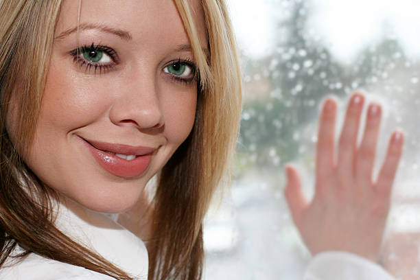 istock Young smiling woman at window 140382958