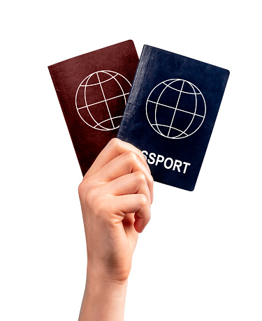 Immigration. Woman hand holding two passports isolated on white background. Multiple, dual nationality, change of citizenship, residency status. High quality photo