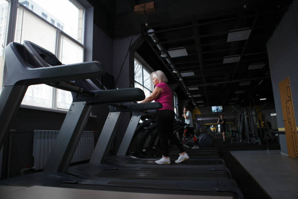 istock Elderly woman exercising at gym 1403831575