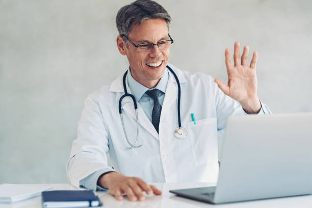 istock Doctor sitting at a desk, using a laptop for a video call 1403833059