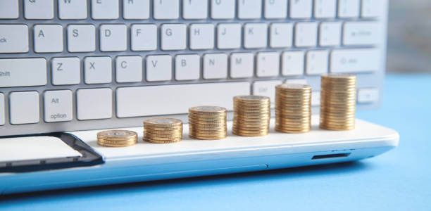 istock Stack of coins on the laptop keyboard. 1403833256