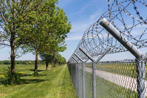 Steel fence, topped with razor wire, protecting a fuel storage facility.  Belfast, Northern Ireland.