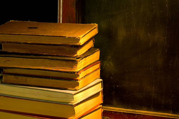 istock Vintage, antique books and old blackboard painted with light 140383498