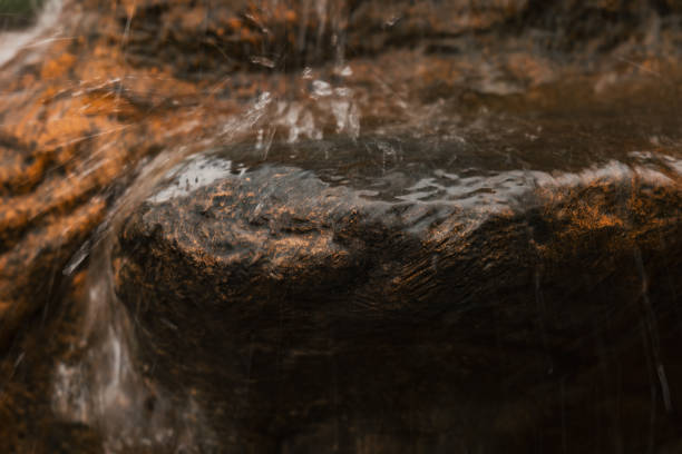 primo piano dell'acqua che cade sulla roccia. spruzzare acqua. effetto acqua sfocata - flowing nature spray rock foto e immagini stock