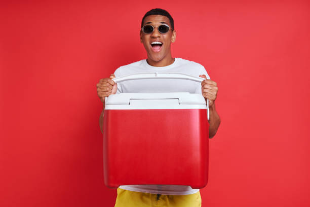 Happy mixed race man carrying cooler box