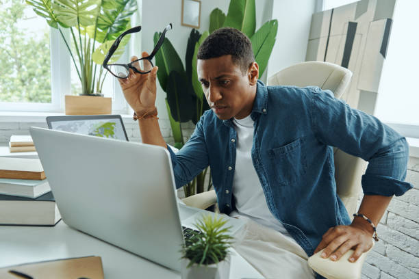 istock Concentrated young mixed race man looking at laptop 1403839058