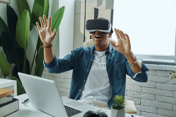 istock Happy mixed race man wearing virtual reality glasses and gesturing 1403839059