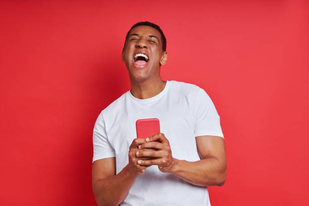 istock Happy mixed race man holding smart phone 1403839071