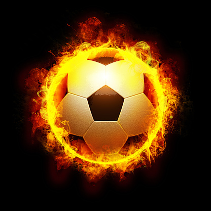Burning soccer ball is on the black background.