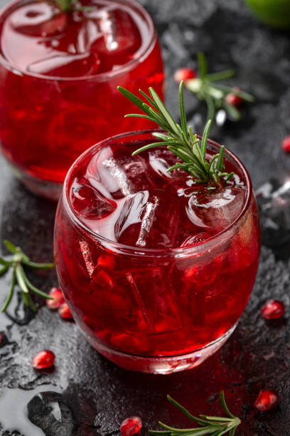 istock Pomegranate gin cocktail with lime, rosemary and ice on rustic black table 1403844957