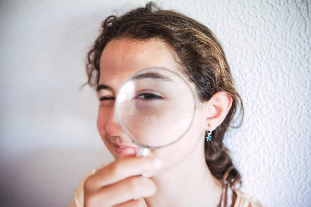 istock Girl looking through a magnifying glass 1403845499