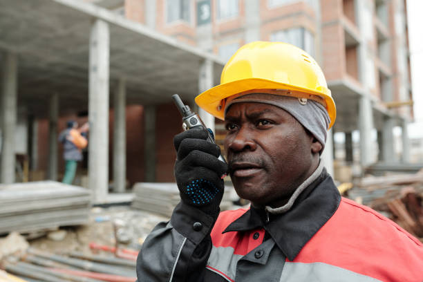 istock Confident African American male engineer in uniform and protective helmet 1403846908