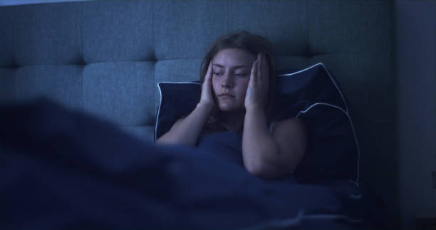 istock Woman in bed can't sleep due to insomnia 1403850348
