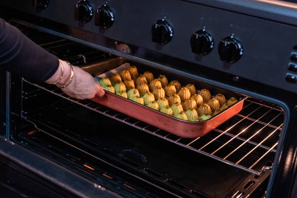 istock Arabic woman hand while putting Keto Eid kahk inside the oven 1403850396