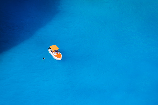 A boat in the lagoon. View of the sea bay and a lone boat from a drone. Blue sea water. Vacation and travel. Summer landscape from the air.