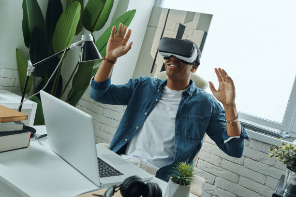 istock Cheerful mixed race man wearing virtual reality glasses 1403852410