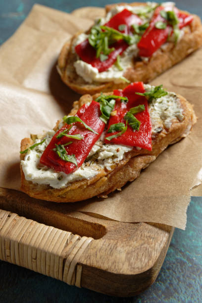 istock Crostini with marinated bell pepper strips on herb cream cheese. 1403853664