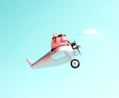 Piggy bank with pilot glasses flying a plane on blue sky background