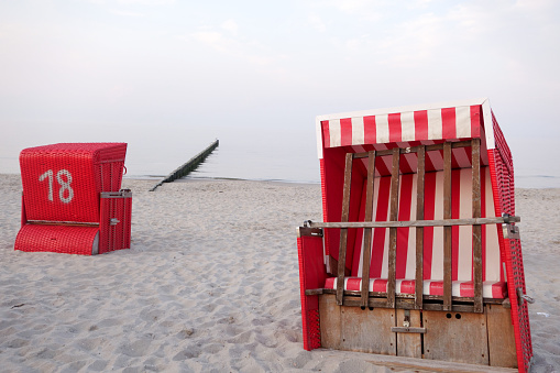 Red and white beach chairs with hood on the Baltic Sea coast