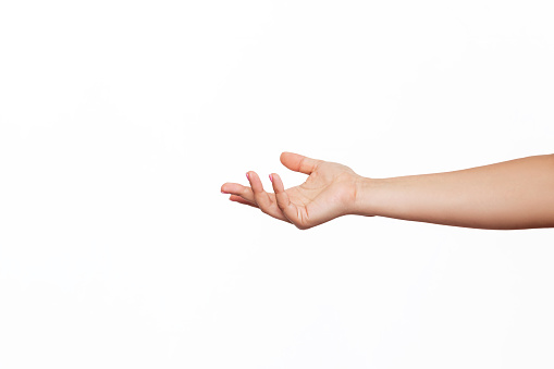 A caucasian female outstretched hand makes a gesture like holding something or asking for help isolated on a white background. Mockup with empty copy space for a intended object