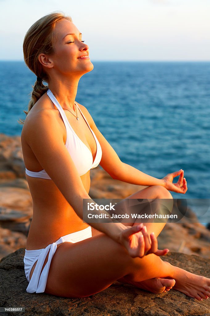 Красивая молодая женщина, Медитировать by the sea - Стоковые фото 20-24 года роялти-фри