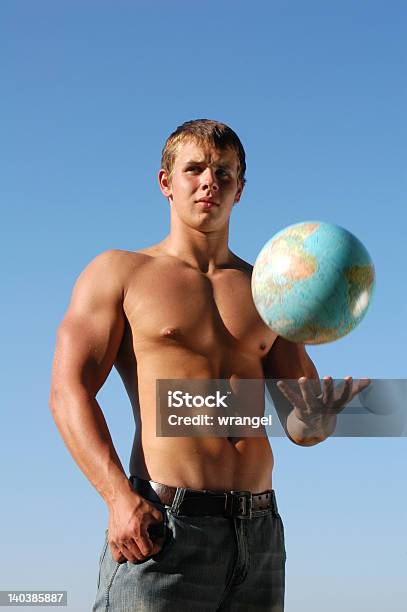 筋肉の若い男が地球のグローブ - つかまえるのストックフォトや画像を多数ご用意 - つかまえる, カジュアルウェア, ジーンズ