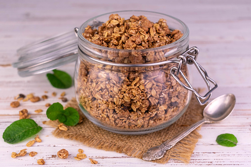 Granola in a jar on a wooden white table.Close-up.