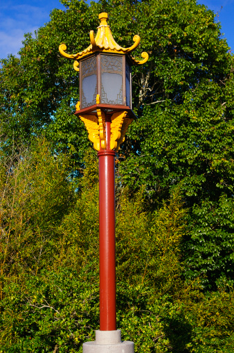 Traditional colorful chinese lamp post against trees background