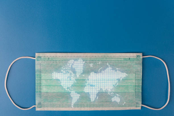 istock White medical protective mask with a world map on a blue background 1403862120