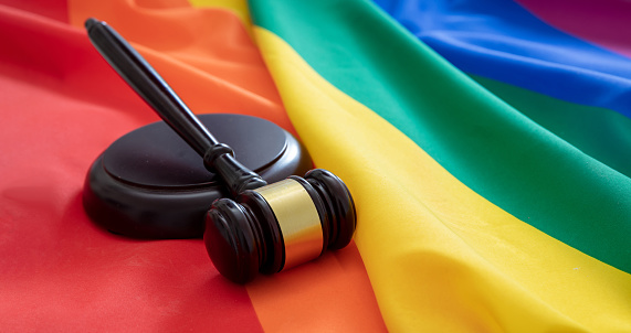 LGBT Law, Gay marriage. Judge gavel on rainbow color textile, close up view. Transgender rights, Copy space