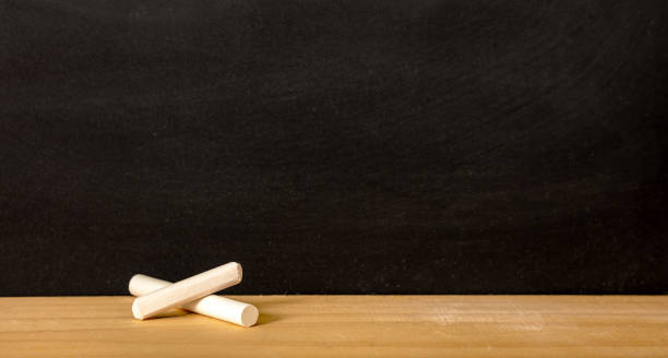 istock School chalkboard, blank empty black board and white chalk piece, copy space 1403862428