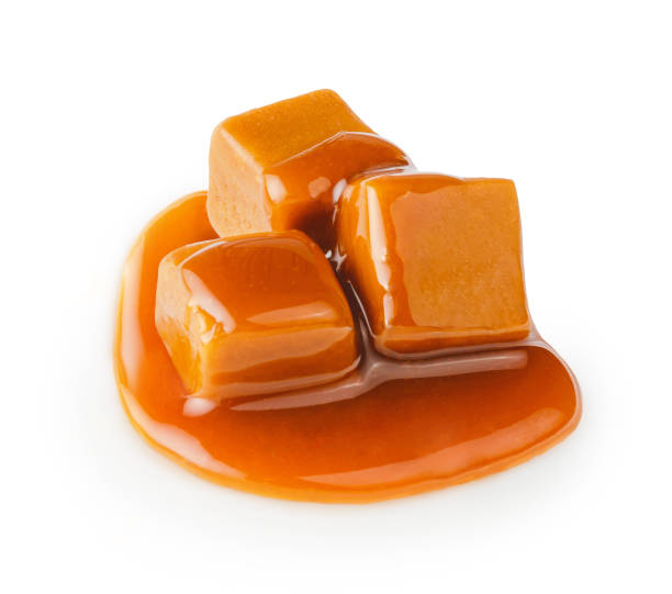 istock Caramel cubes with caramel sauce isolated on white background. 1403863309