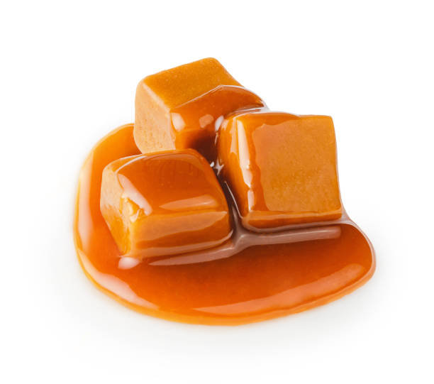 Caramel cubes with caramel sauce isolated on white background. stock photo