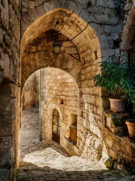 A stone arch in Lacoste frames one of the narrow streets in this Luberon hilltown.