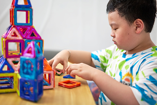 boy building a toy house be creative