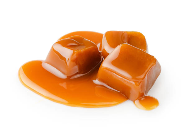 istock Caramel cubes with caramel sauce isolated on white background. 1403863587