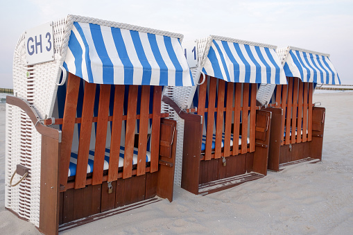 Blue and white beach chairs with hood on the Baltic Sea coast