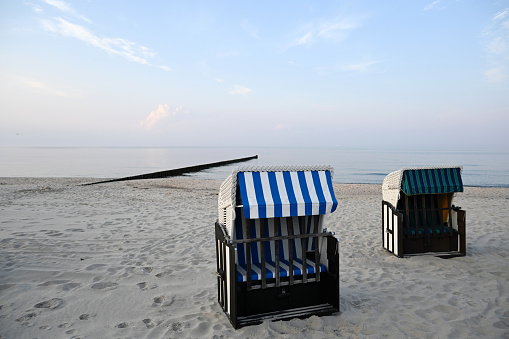Blue and white beach chairs with hood on the Baltic Sea coast