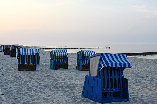 Blue and white beach chairs with hood on the Baltic Sea coast